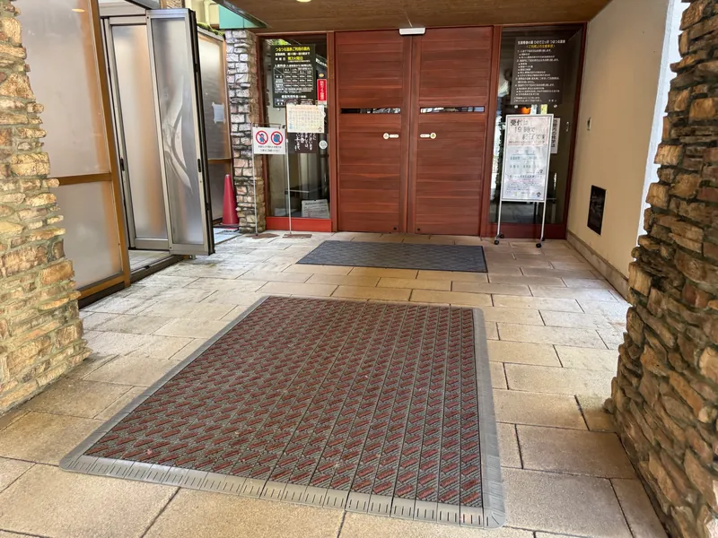 風除室から館内へ続くタイルとマットと自動ドア